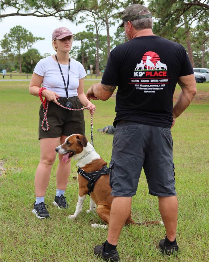 dog training at k9s place with an instructor and an owner talking about her dog